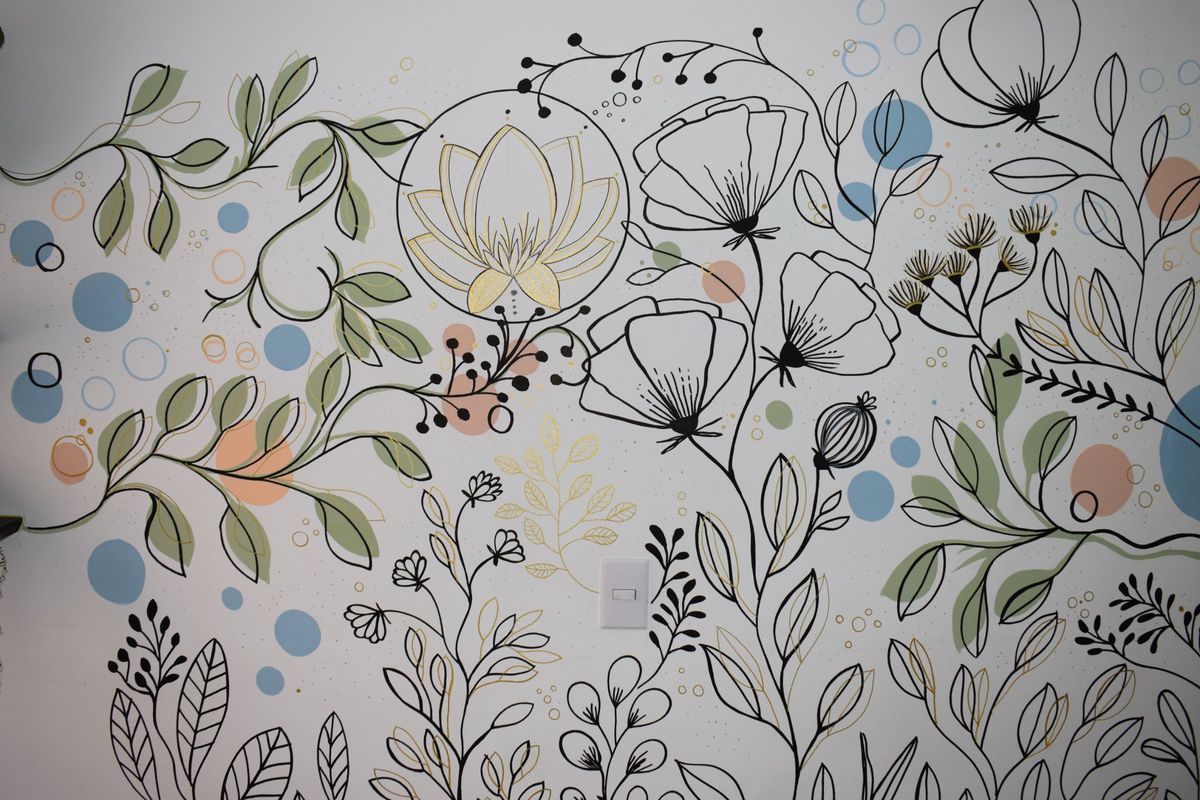 Mural de flores, hojas y un loto dorado pintado por Nathalia